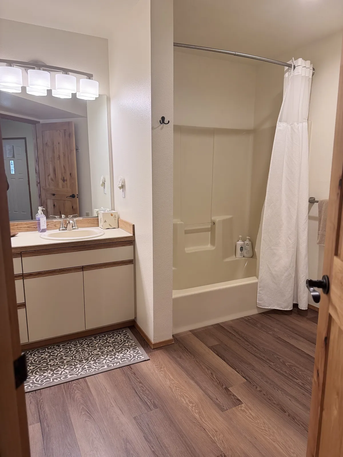 Bathroom with a bathtub, white vanity and mirror